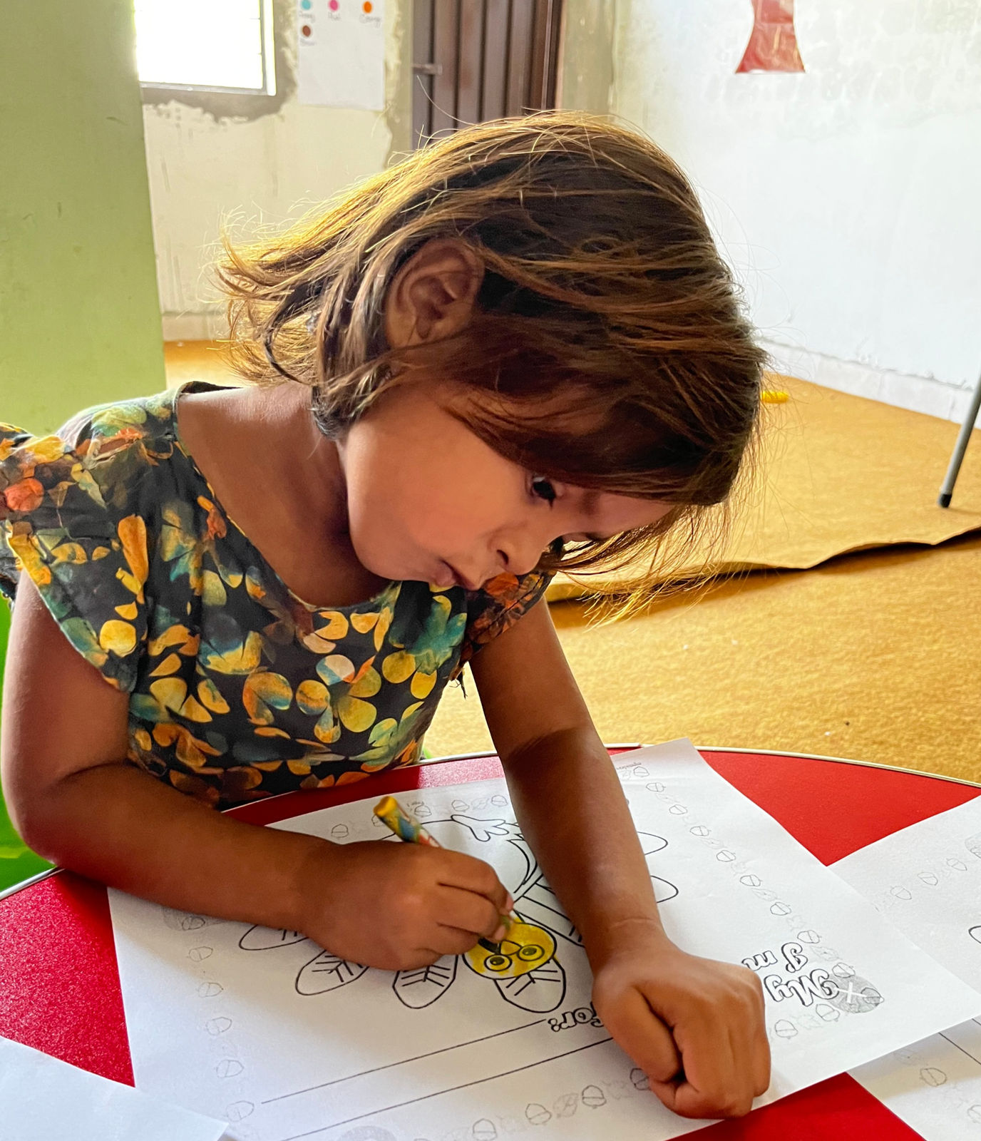 A young girl colouring a worksheet at BrightColoursOrphanage in Lahore