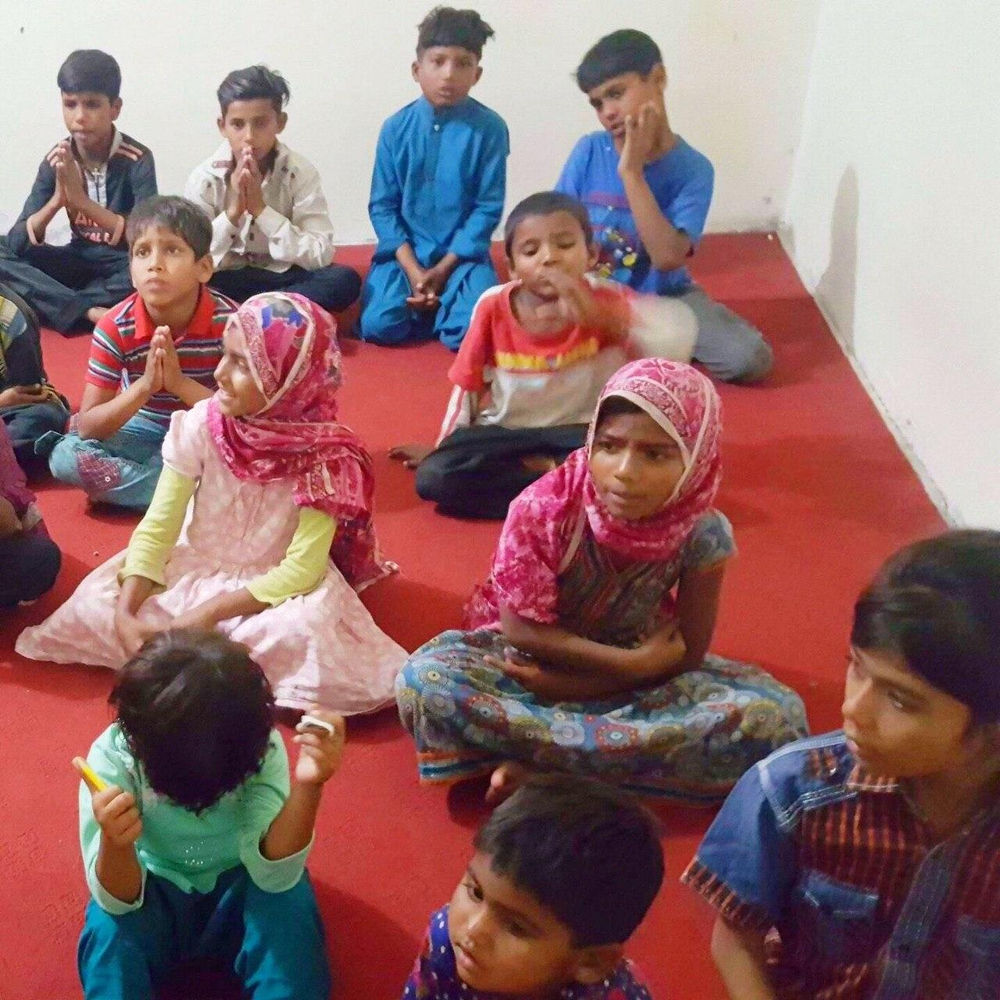 Children sitting together during prayer time at BrightColoursOrphanage
